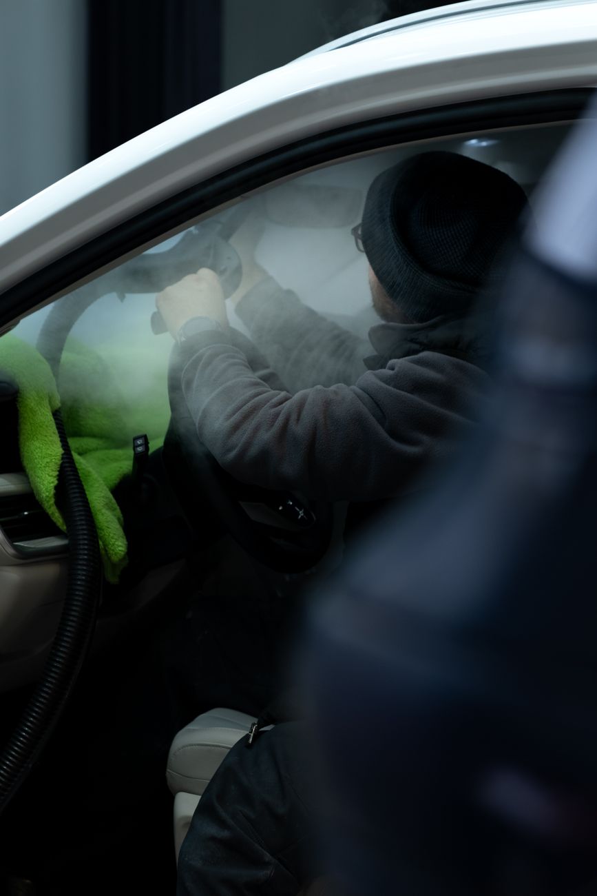 Detailer die met stoom een auto-interieur reinigt