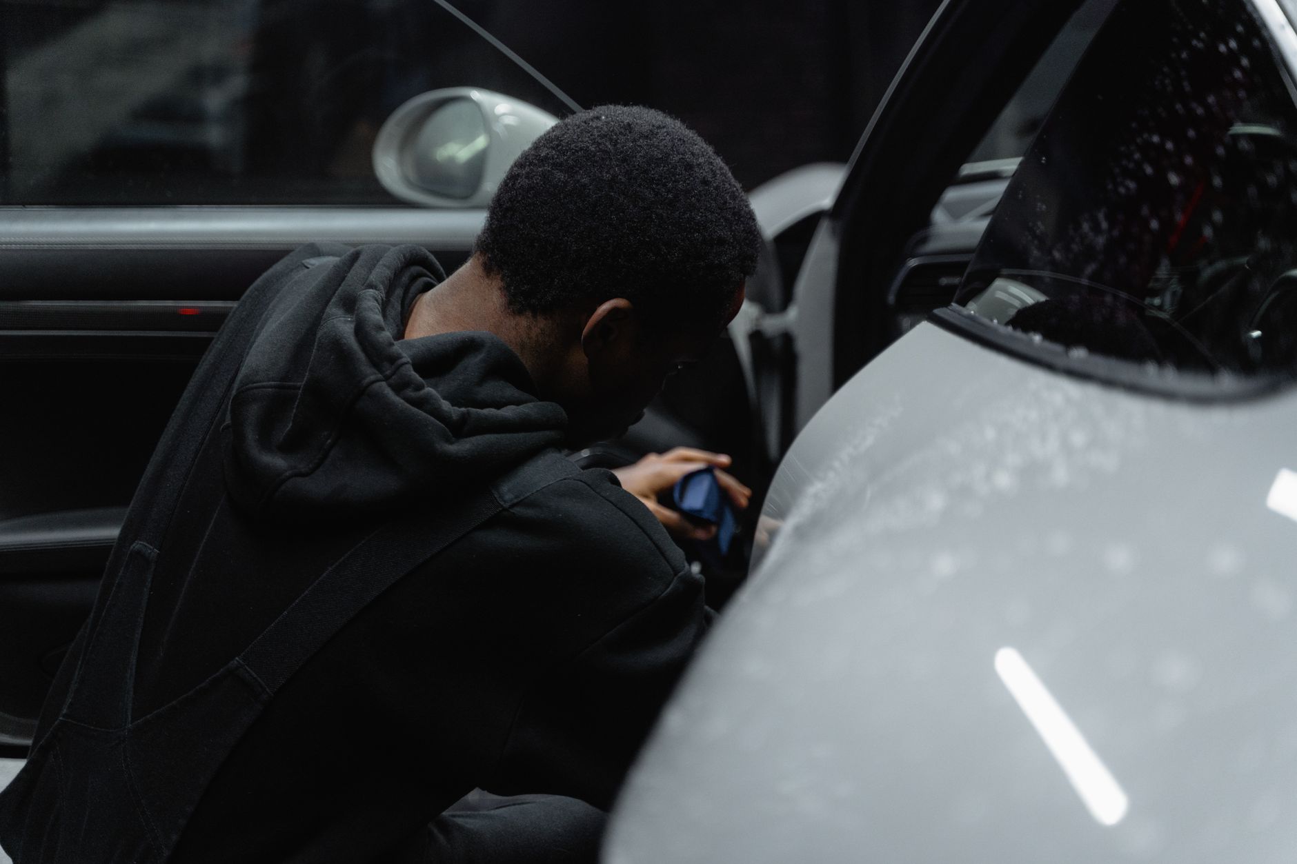 Detailer die bij gedempt licht een auto-interieur behandelt